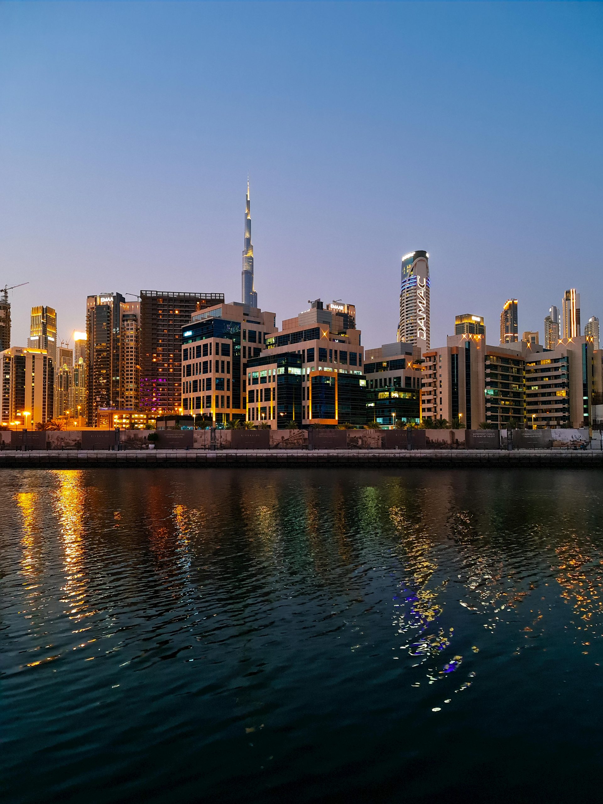 A captivating view of Dubai's skyline featuring the iconic Burj Khalifa set against a twilight sky reflecting on the water.